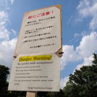A photo taken Tuesday shows a notice in Yoyogi Park warning visitors about mosquitoes. The Tokyo Metropolitan Government decided Thursday to close certain areas today due to the discovery of mosquitoes carrying dengue fever. | SATOKO KAWASAKI