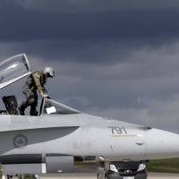 A Canadian Air Task Force pilot leaves his CF-188 jet after landing at Siauliai Air Base in Lithuania on Aug. 26. The Royal Canadian Air Force handed over their air policing mission over the Baltics to NATO on Monday. | REUTERS