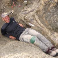 American paleontologist Kenneth J. Lacovara poses in 2007 by a tibia bone of a Dreadnoughtus dinosaur at an excavation site in Southern Patagonia in Argentina. The supermassive dinosaur, which would have weighed as much as 60 small cars, is believed to have  perished in a bog some 77 million years ago, palaeontologists said September 4, 2014. Lacovara, an associate professor in Drexel University\'s College of Arts and Sciences, discovered the Dreadnoughtus fossil skeleton in southern Patagonia in Argentina and led the excavation and analysis. The fossil was unearthed over four field seasons from 2005 through 2009 by Lacovara and his team. | AFP-JIJI