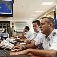 Greek coast guard officers work at the Maritime Rescue Coordination Center at the Shipping Ministry in Piraeus, near Athens, on Thursday. Greece is slipping into a \"danger zone\" without the funds or resources to handle a fast-growing wave of refugees trying to enter the European Union from war-torn countries like Syria and Iraq, the government warned. | REUTERS