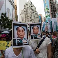 Protesters hold banners depicting a caricature of Leung Chun-ying, Hong Kong\'s chief executive, during a rally in the city on July 1. The rally was an annual event marking the anniversary of Hong Kong\'s return to Chinese rule in 1997. | BLOOMBERG