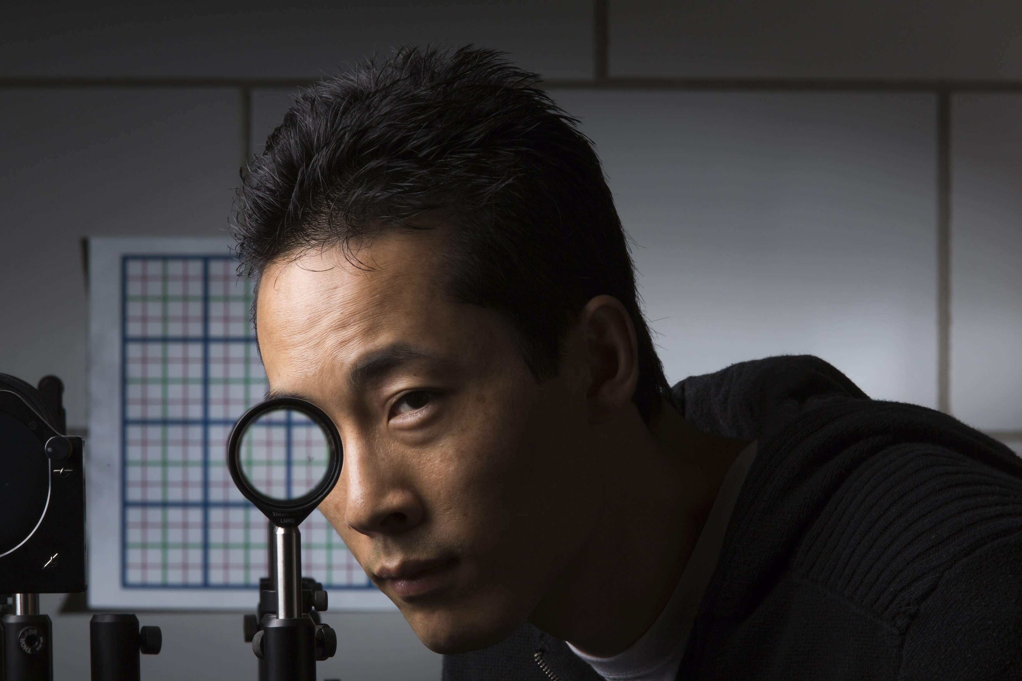 University of Rochester Ph.D. student Joseph Choi demonstrates a cloaking device using four lenses in Rochester, New York on Sept. 11. | REUTERS