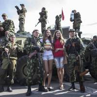 Women pose with pro-Russian rebels during a parade in Luhanks, eastern Ukraine, on Sunday. Ukraine\'s defenae minister said the same day that NATO countries were delivering weapons to his country to equip it to fight pro-Russian separatists and \"stop\" Russian President Vladimir Putin. | REUTERS