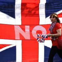 One of about 12,000 loyalists taking part in an emotional show of support to keep Scotland within the United Kingdom rallies in front of a huge Union Jack in the center of the Scottish capital, Edinburgh, on Saturday. A referendum on whether to end Scotland\'s 307-year-old union with the rest of the U.K. will take place Thursday. | REUTERS
