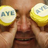 SNP leader Alex Salmond visits Brownings bakery in Kilmarnock, Scotland, on Wednesday, where he was presented with \"Aye\" branded cakes in support of the independence campaign. The British pound slipped sharply after an opinion poll on Tuesday revealed a jump in the number of people advocating severance of the country\'s 307-year union with the U.K. | AP