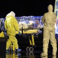 Medical personnel transfer a Spanish Ebola patient who contracted the virus in Sierra Leone, at a military air base near Madrid on Monday. As the West grapples with the threat of Ebola, many countries, the United States in particular, face challenges with handling medical waste produced by patients with the virus. | AP