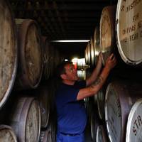 An employee checks a cask of Chivas Regal blended Scotch whisky at Pernod Ricard SA\'s Strathisla distillery in Keith, Scotland, on Aug. 5. | BLOOMBERG