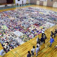 A patchwork blanket made from donated knitted squares appears to have set a new world record. The blanket is the work of a German resident of Yokohama and around 80 people living in disaster-hit Ishinomaki, Miyagi Prefecture. | KYODO