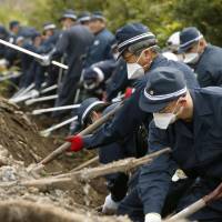 Police search for the remains of people still missing since the March 11, 2011, disasters in Namie, Fukushima Prefecture, on Thursday. | KYODO