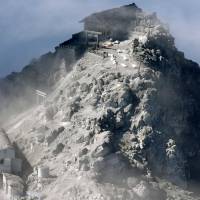 Bodies are laid out on the ground near the top of Mount Ontake on Tuesday morning after rescue operations were halted due to dangers from volcanic tremors and fumes. | KYODO
