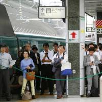 Passengers wait on a platform at Tokyo Station for bullet train service to resume on Wednesday. | KYODO
