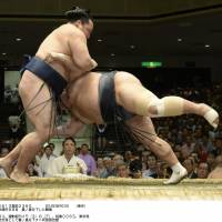 No trouble at all: Kakuryu makes short work of Toyonoshima on the eighth day of the Autumn Grand Sumo Tournament on Sunday. | KYODO