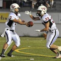 Team effort: Waseda freshman quarterback Haruki Sakanashi hands off the ball to sophomore running back Kazuhiro Sugai in the second quarter against Nihon University on Sunday in the Kanto Collegiate League. Nihon won 14-7. | HIROSHI IKEZAWA