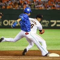 First line of defense: Yomiuri pitcher Tetsuya Utsumi (right) gets Yokohama\'s Takehiro Ishikawa out at first base during the Giants\' 4-0 win over the BayStars on Friday. | KYODO