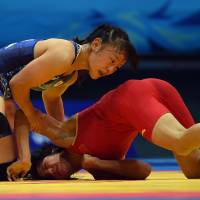 The winning strategy: Eri Tosaka pins down China’s Sun Yanan during the women’s freestyle 48-kg gold medal match at the Asian Games on Saturday. Tosaka, Watari collect wrestling golds