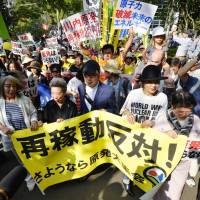 Demonstrators march through a park in Koto Ward, Tokyo, on Tuesday in opposition to the planned restart of the Sendai nuclear plant in Kagoshima Prefecture. Participants included Nobel Prize-winning author Kenzaburo Oe (at front, center). | KYODO