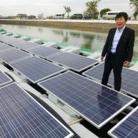 Solar panels float on a pond in Ono, Hyogo Prefecture, on Wednesday. Osaka Gas Co. says the system is due to begin operating Saturday. The gas company aims to grow its floating solar panel business to cope with the dearth of land for housing solar farms. | KYODO