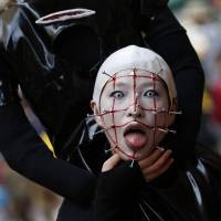 A participant in costume poses for a picture before a Halloween parade Sunday in Kawasaki. More than 100,000 spectators turned up to watch the parade of 2,500 participants, according to the organizer. | REUTERS