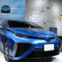 Toyota Motor Corp. shows off a fuel-cell sedan at the CEATEC consumer electronics show at Makuhari Messe in Chiba Prefecture on Tuesday. The carmaker says it will start selling fuel-cell vehicles in April. | KAZUAKI NAGATA