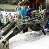 Researchers from Tokyo University of Science demonstrate a new nursing robot at Japan Robot Week 2014 on Wednesday at Tokyo Big Sight. | AP