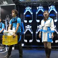 Tokyo University of Science personnel hold a demonstration using a wearable robot called Muscle Suit. | KAZUAKI NAGATA