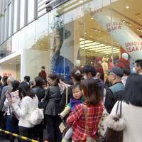 People wait in line outside Uniqlo\'s new flagship outlet in Kita Ward, Osaka, on Friday morning. | KYODO