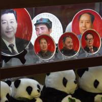 Decorative plates featuring Chinese leaders (front, from left) President Xi Jinping, Mao Zedong, Deng Xiaoping, Jiang Zemin and Hu Jintao are displayed in a shop window in Beijing as leaders of the ruling Communist Party on Monday convened a four-day policy meeting. | AFP-JIJI
