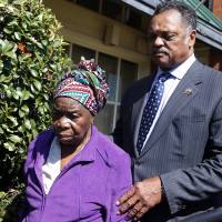 The Rev. Jesse Jackson walks with Nowai Korkoyah, the mother of Thomas Eric Duncan, the first patient diagnosed with Ebola on U.S. soil, in Dallas on Tuesday. Duncan remains in critical condition, he is on a ventilator and receiving kidney dialysis, the Dallas hospital treating him said on Tuesday. | REUTERS