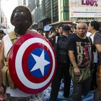 A pro-democracy protester with a shield made to resemble the one wielded by comic book character Captain America takes part in a demonstration in the Hong Kong\'s Mongkok district Monday. | AFP-JIJI