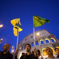 Kurdish supporters demonstrate in front of Rome\'s Colosseum on Wednesday. The activists are demanding more help for the besieged Kurdish forces struggling to hold onto the Syrian town of Kobani. Jihadists fighting to take the strategic town advanced into the outskirts despite intensified U.S.-led airstrikes, as deadly protests over the fate of its Kurdish residents shook neighboring Turkey. | AFP-JIJI