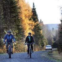 Nurse Kaci Hickox and her boyfriend, Ted Wilbur, are followed by a Maine State Trooper as they ride bikes on a trail near their home in Fort Kent, Maine, Thursday.  State officials are going to court to keep Hickox in quarantine for the remainder of the 21-day incubation period for Ebola that ends on Nov. 10. Police are monitoring her, but can\'t detain her without a court order signed by a judge. | AP