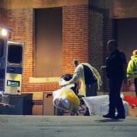 A man collects items behind the ambulance used to transport a patient with possible Ebola symptoms to Beth Israel Deaconess Medical Center in Boston on Sunday. | REUTERS