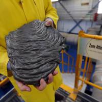 A technician holds a flow of corium at the Cadarache CEA site near Saint-Paul-les-Durance, France, on Sept. 26. | REUTERS