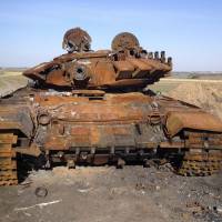 A T-72 tank that apparently came from Russia sits on a battlefield in Ukraine on Oct. 2. | REUTERS
