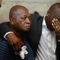 Orlando Pirates teammate Lucky Lekgwathi (right) with Sam Meyiwa (second from left), the father of slain national soccer team skipper Senzo Meyiwa, mourn at the family home of Senzo Meyiwa in Umlazi, near Durban, South Africa on Tuesday. The national soccer captain was shot and killed at the home of his girlfriend in Vosloorus, east of Johannesburg, Sunday night during a robbery attempt. He will be laid to rest Saturday at a funeral in Umlazi. Manhunt on for killers of South Africa soccer captain