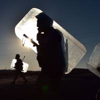 Turkish troops patrol the border with Syria near the city of Sanliurfa on Saturday. Kurdish fighters supported by U.S.-led airstrikes held back jihadis attacking the dusty Syrian border town of Kobani on the frontier with Turkey, a key battleground between the Islamic State group and their opponents. | AFP-JIJI