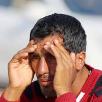 A Turkish Kurd watches as fighting intensifies between Kurds fighters and Islamic State militants in Kobani, Syria, on Saturday. | AP