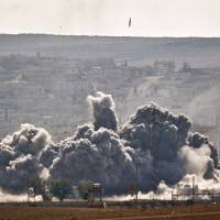 A bomb falls on an a position held by Islamic State fighters in the town of Kobani during airstrikes by the U.S.-led coalition on Tuesday. | AP
