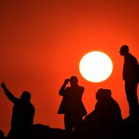Kurds observe the Syrian town of Kobani from the Turkish border on Saturday as militants from the Islamic State group continued a ferocious assault on the town. The extremist group has attracted growing numbers of recruits from the West, and Britain, which has tried and failed to prevent young Muslims from becoming radicalized, may have lessons for other countries. | AFP-JIJI