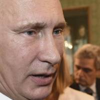 Russian President Vladimir Putin talks with French President Francois Hollande on the sidelines of the Europe-Asia summit in Milan on Friday. | REUTERS
