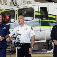 Chief of Miami-Dade Air Resue Antonio Hernandez talks to reporters during a news conference as Coast Guard Cmdr. Respond Sector Chief Richard Hartley (left) and Miami-Dade Fire Rescue flight medic Eric Lowd look on, in Miami on Monday. The U.S. Coast Guard said an overturned raft was reported Monday morning in Biscayne Bay, and 10 Cuban migrants have been found and three more remain unaccounted for in the waters off Miami. | AP