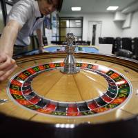 An employee works the roulette wheel at the Japan Casino School in Tokyo in June. | BLOOMBERG