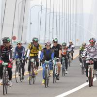 Cyclists cross the Tatara Bridge on the Nishiseto Expressway, commonly known as Shimanami Kaido, during the Cycling Shimanami event Sunday. | KYODO