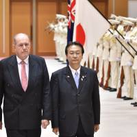 Australian Defense Minister David Johnston and Japanese counterpart Akinori Eto review an honor guard before their talks at the Defense Ministry in Tokyo Thursday. | AFP-JIJI