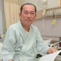 Yuki Sanbonsugi, former vice principal of Tomioka Dai-ichi Junior High School, holds a document filled with some of his blog messages in an undated photo. | FUKUSHIMA MINPO