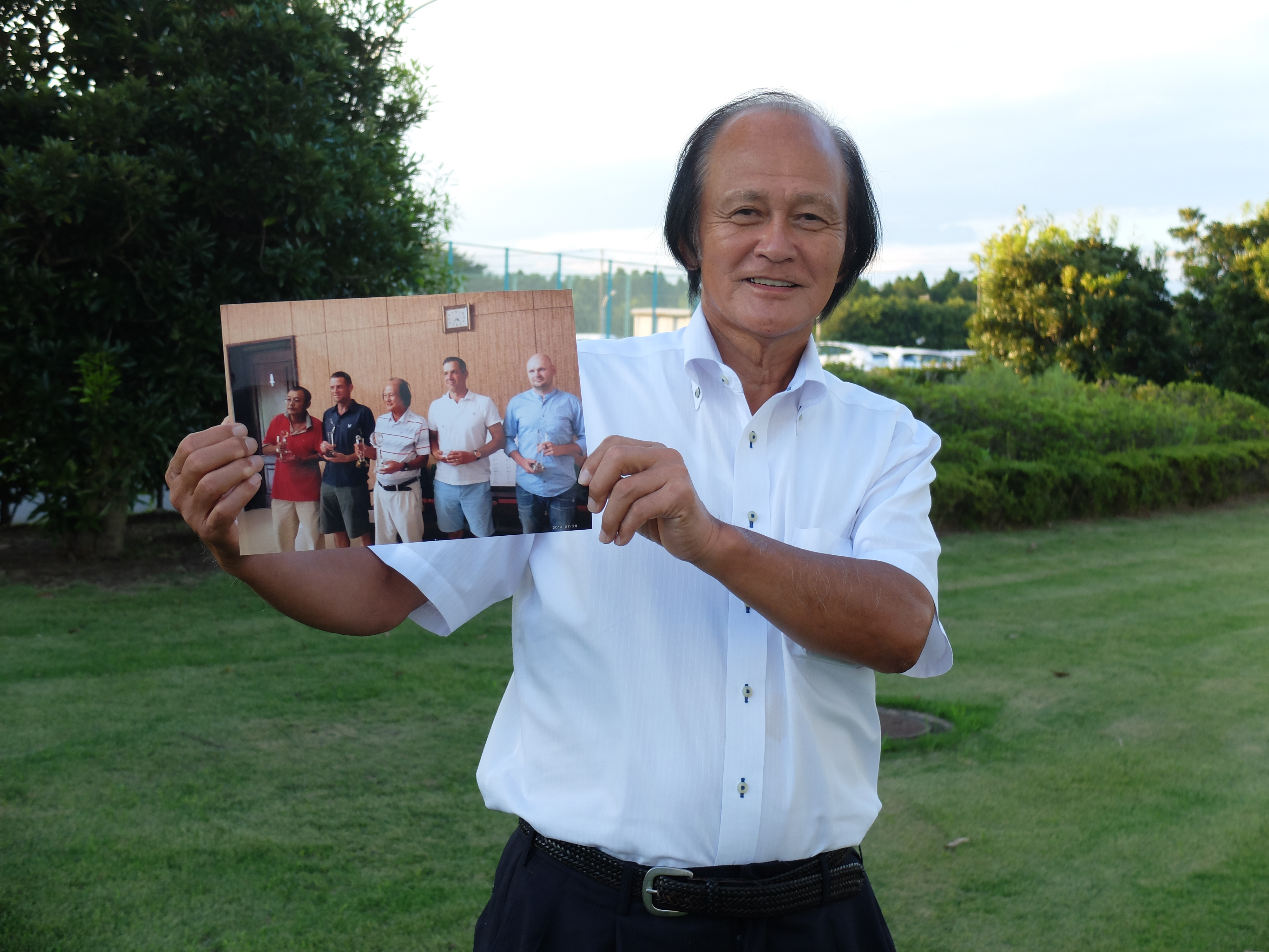Nobuaki Kasahara holds a photo of himself taken in Pyongyang during an interview with The Japan Times in Ushiku, Ibaraki Prefecture, on Sept. 2. | MAGDALENA OSUMI