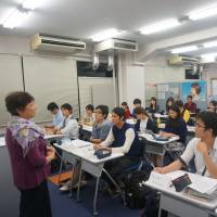 Journalist Mutsuko Murakami teaches students at Hosei University in Tokyo on Oct. 13 as they begin work on their own English-language newspaper. The joint project with The Japan Times aims to teach a range of skills. | HOSEI UNIVERSITY