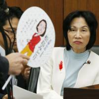 Justice Minister Midori Matsushima (right) is questioned in the Lower House on Oct. 15 about her distribution of \"uchiwa\" fans in her electoral district, an action the Democratic Party of Japan alleged constituted a violation of the election campaign law. Matsushima resigned her Cabinet post Monday. | KYODO