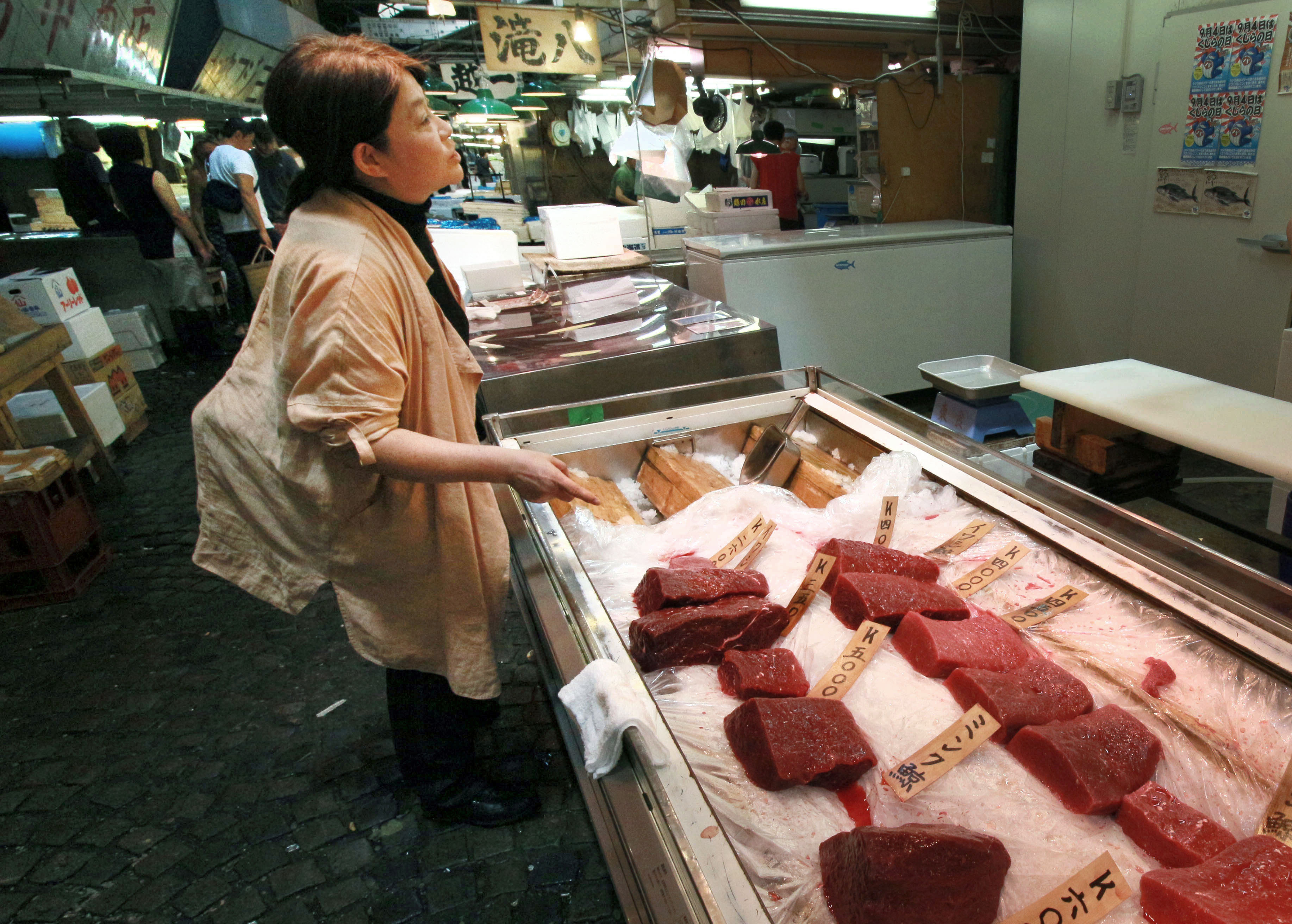 Junko Sakuma visits a store selling whale meat in the Tsukiji fish market in Tokyo on Aug. 5. She says annual consumption in Japan is less than 30 grams per person. | KYODO
