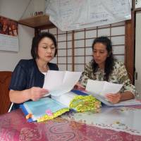 Facing reality: National HPV Vaccine Victims Network Association founders Toshie Ikeda (left) and Mika Matsufuji look through victims\' case files in Tokyo in September. | MASAMI ITO